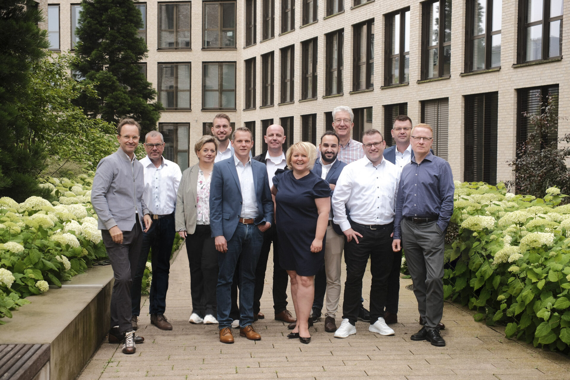 Ein Teambild im Innenhof des Bürogebäudes.
